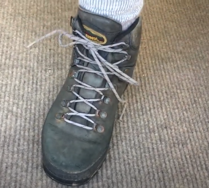 El nudo final debe quedar abajo de los ganchos superiores.